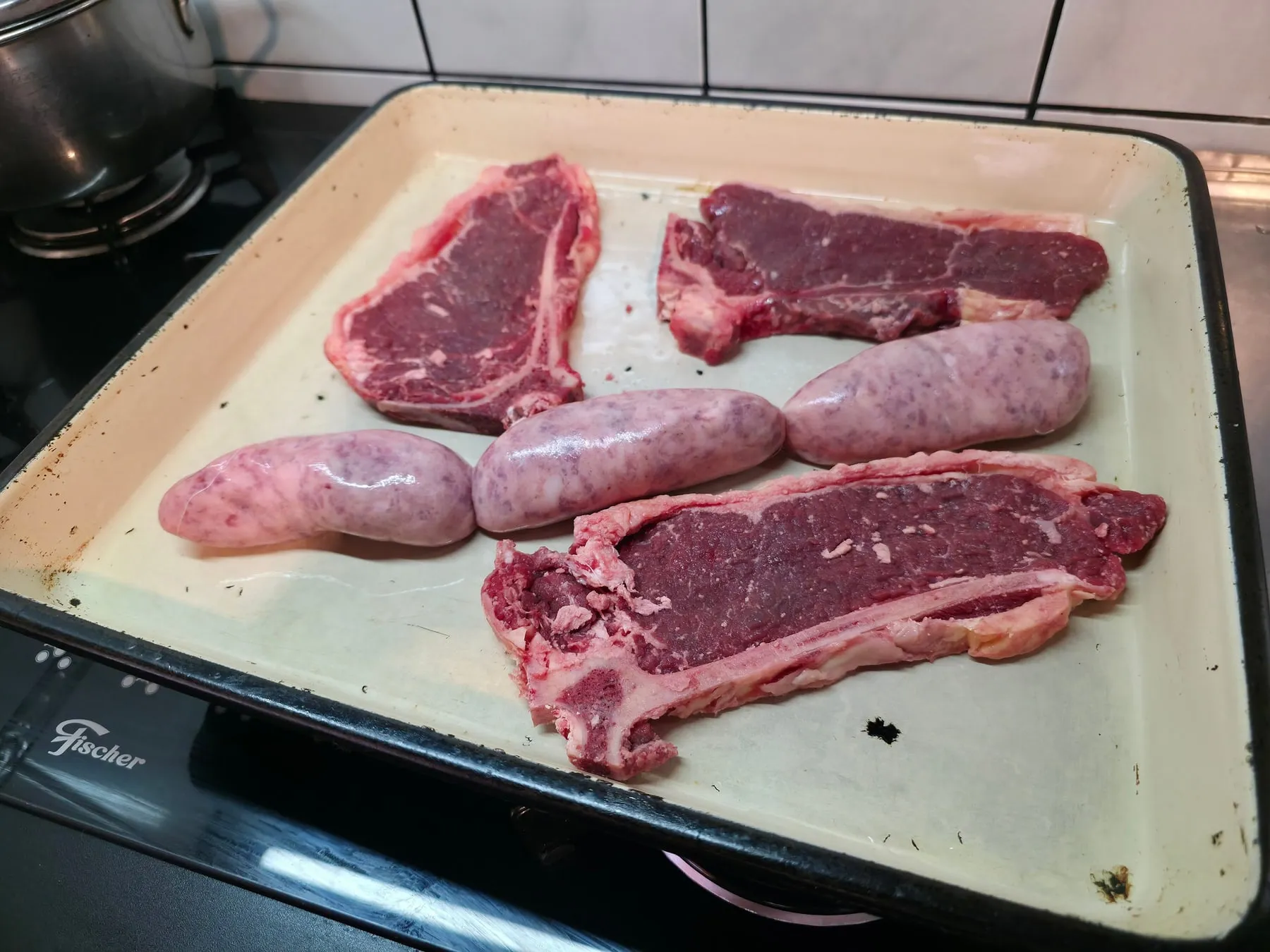Bifes de chorizo y chorizos crudos en una fuente